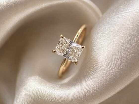 Anillo de compromiso con diamante corte radiante sobre tela de satín
