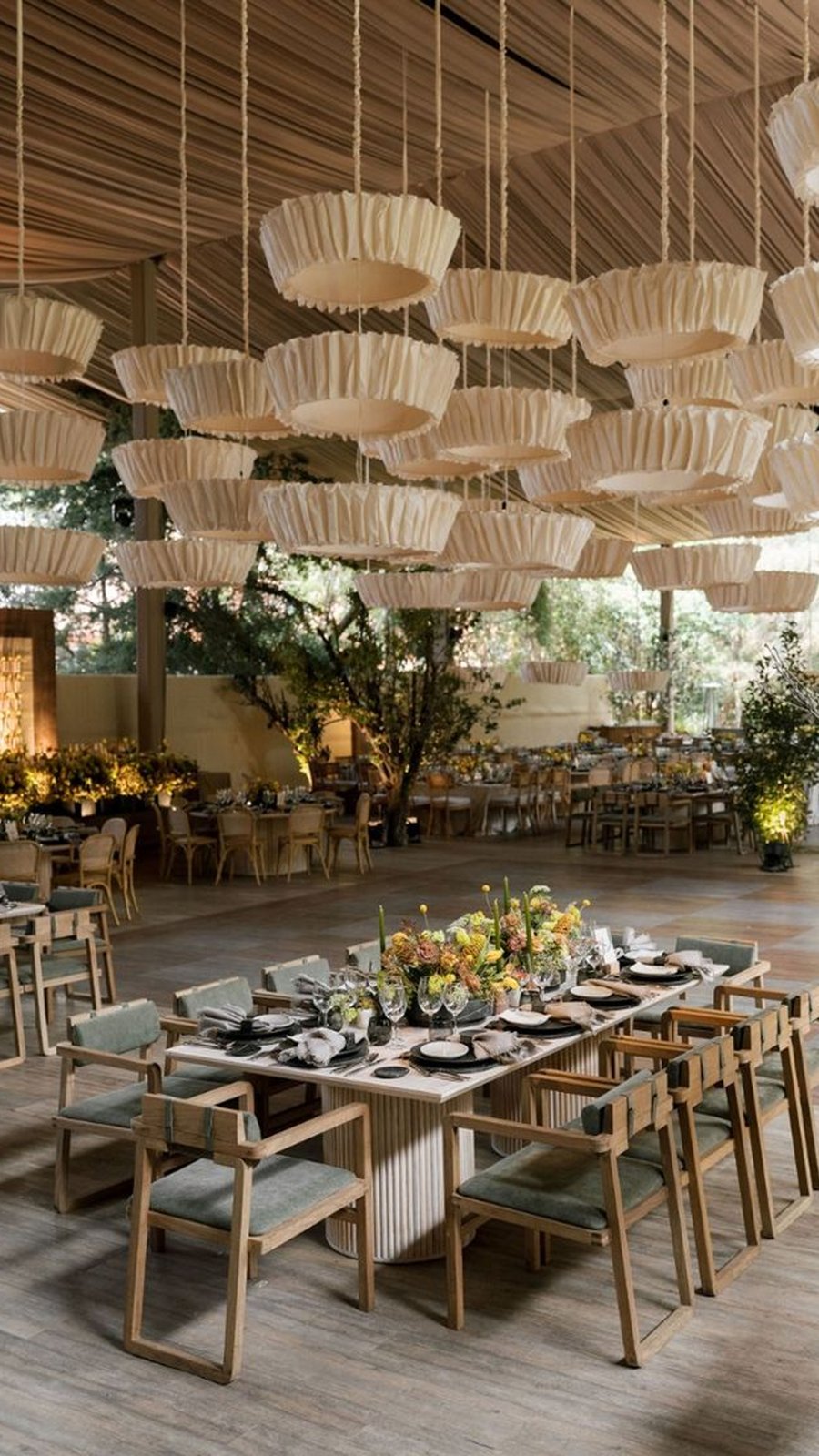 Montaje de banquete con lámparas de papel colgantes en un venue contemporáneo