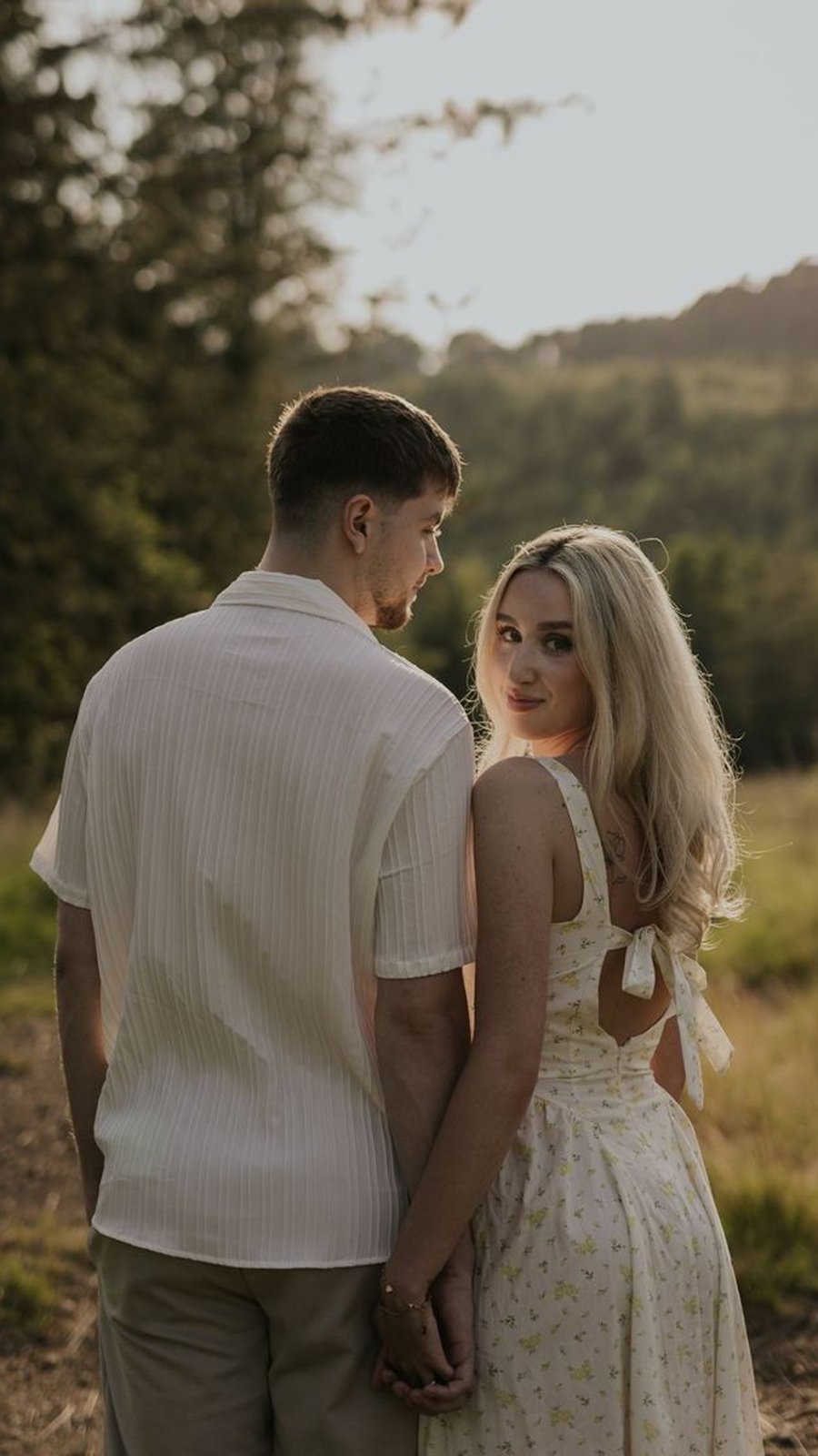 Pareja abrazada en un campo al atardecer