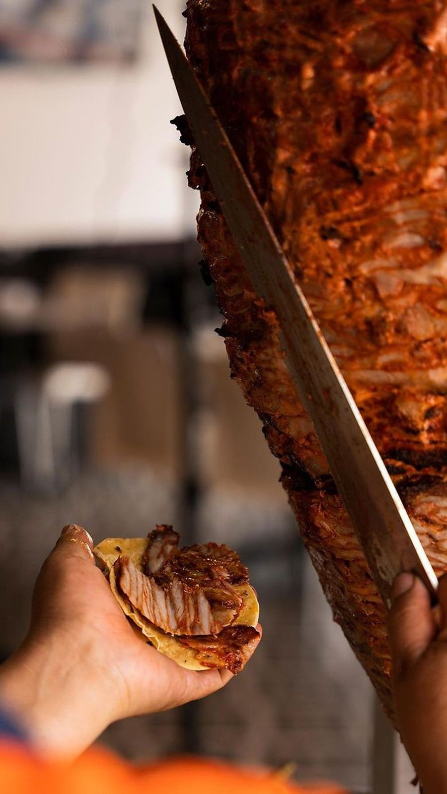 Taquero corta carne al pastor del trompo