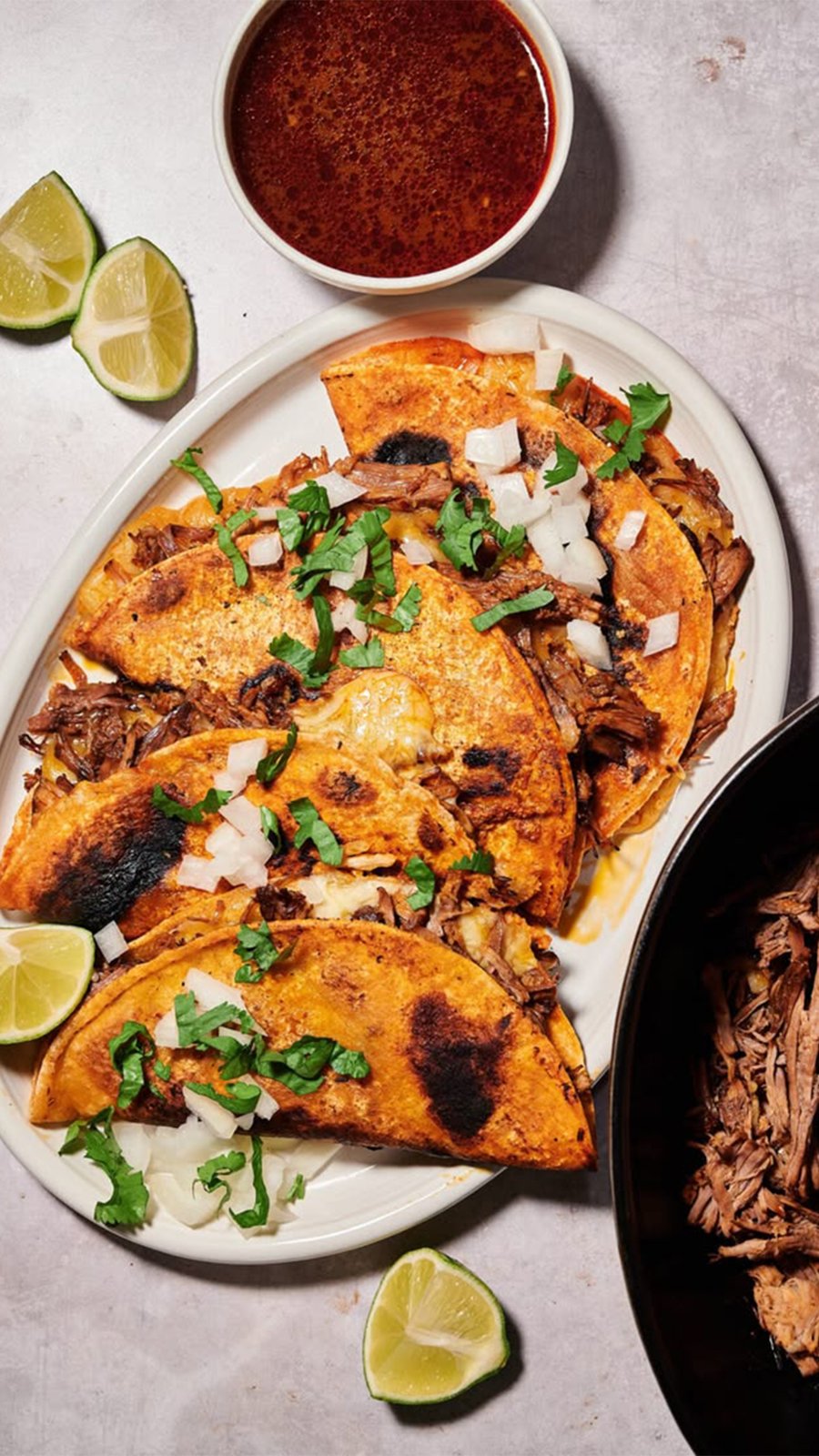 Tacos de birria dorados con cebolla, cilantro y consomé