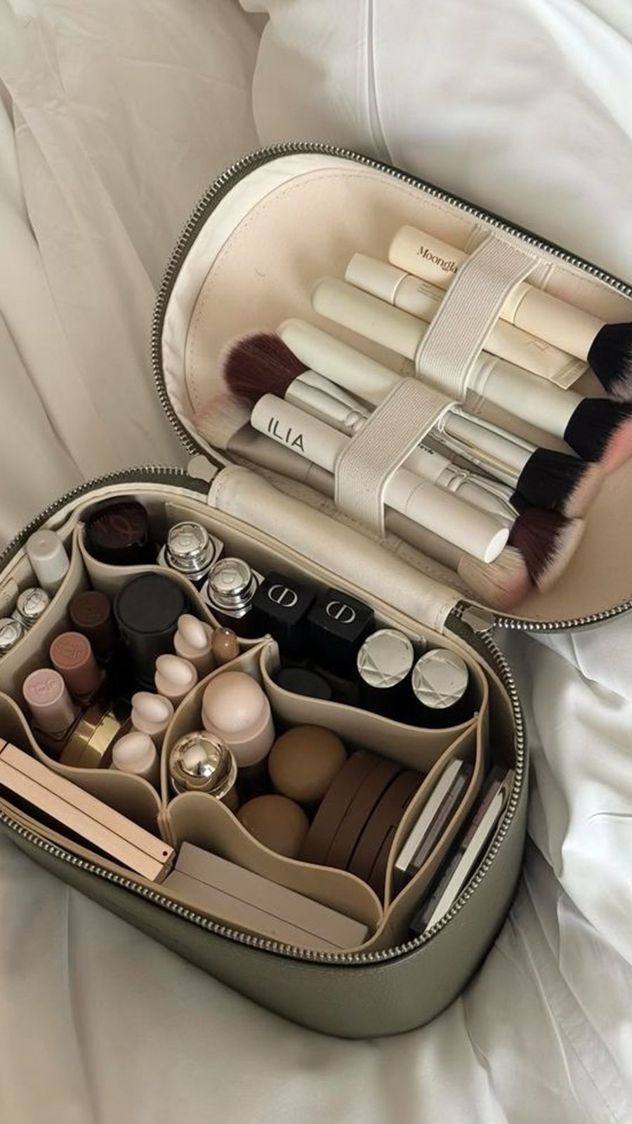 Estuche de maquillaje abierto con brochas y productos para retoques