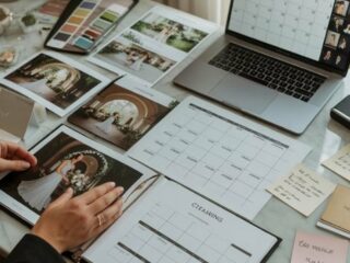 Mesa de planeación de boda con laptop, calendario, paleta de colores y fotos de inspiración