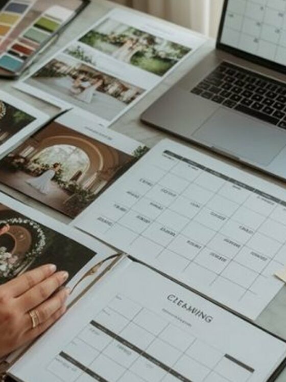 Mesa de planeación de boda con laptop, calendario, paleta de colores y fotos de inspiración
