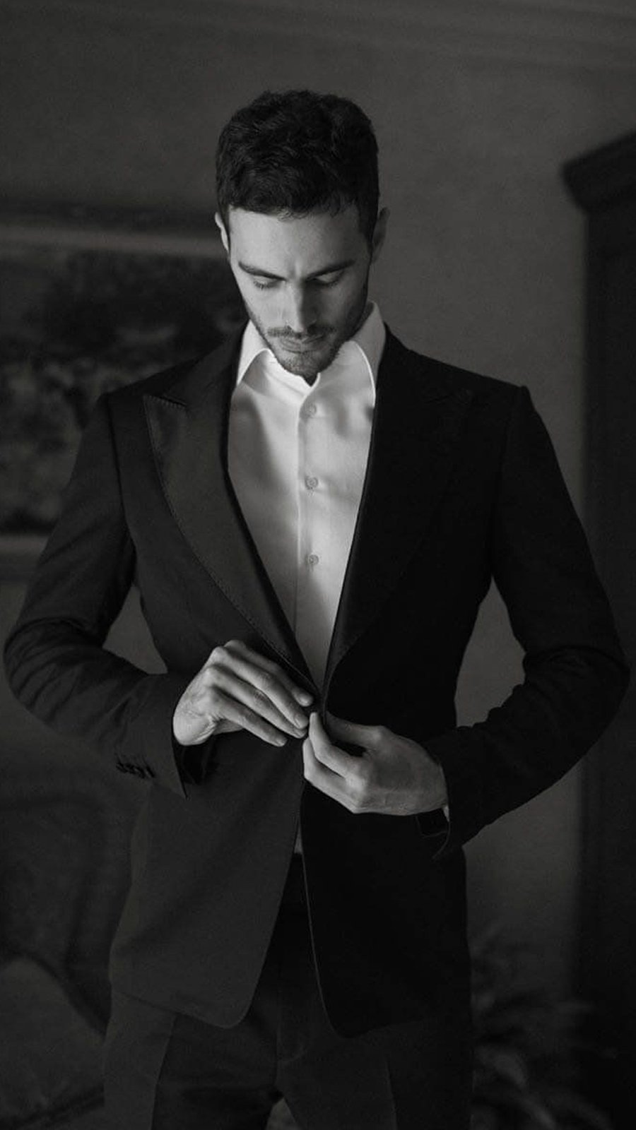 Novio se abotona el saco, en blanco y negro