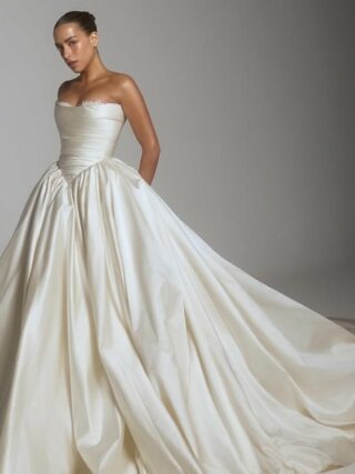 Novia con vestido strapless de satín y falda voluminosa con cauda