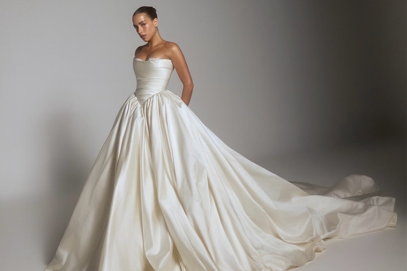 Novia con vestido strapless de satín y falda voluminosa con cauda
