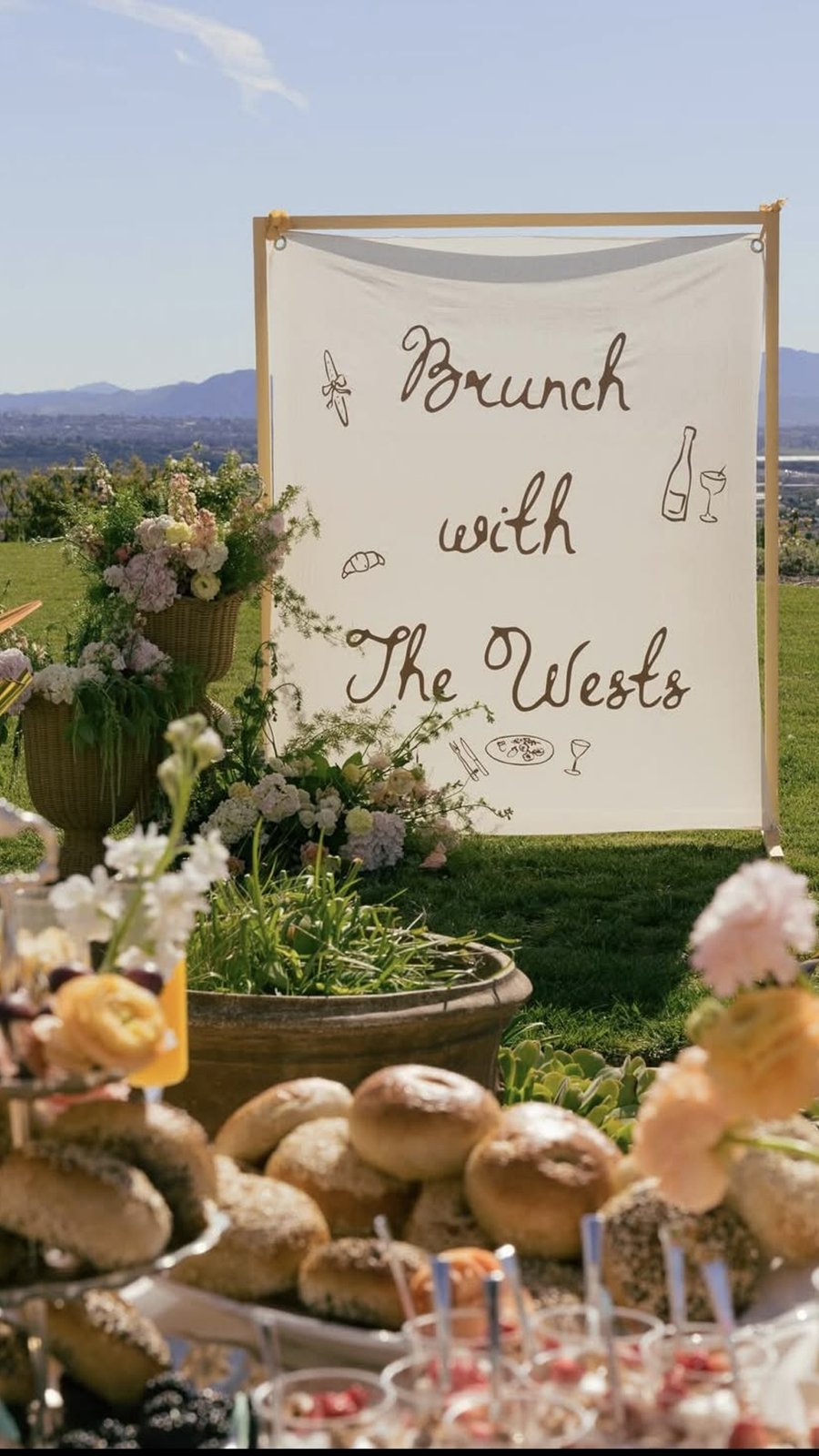 Mesa de brunch con pan y flores bajo un letrero de Brunch with The Wests