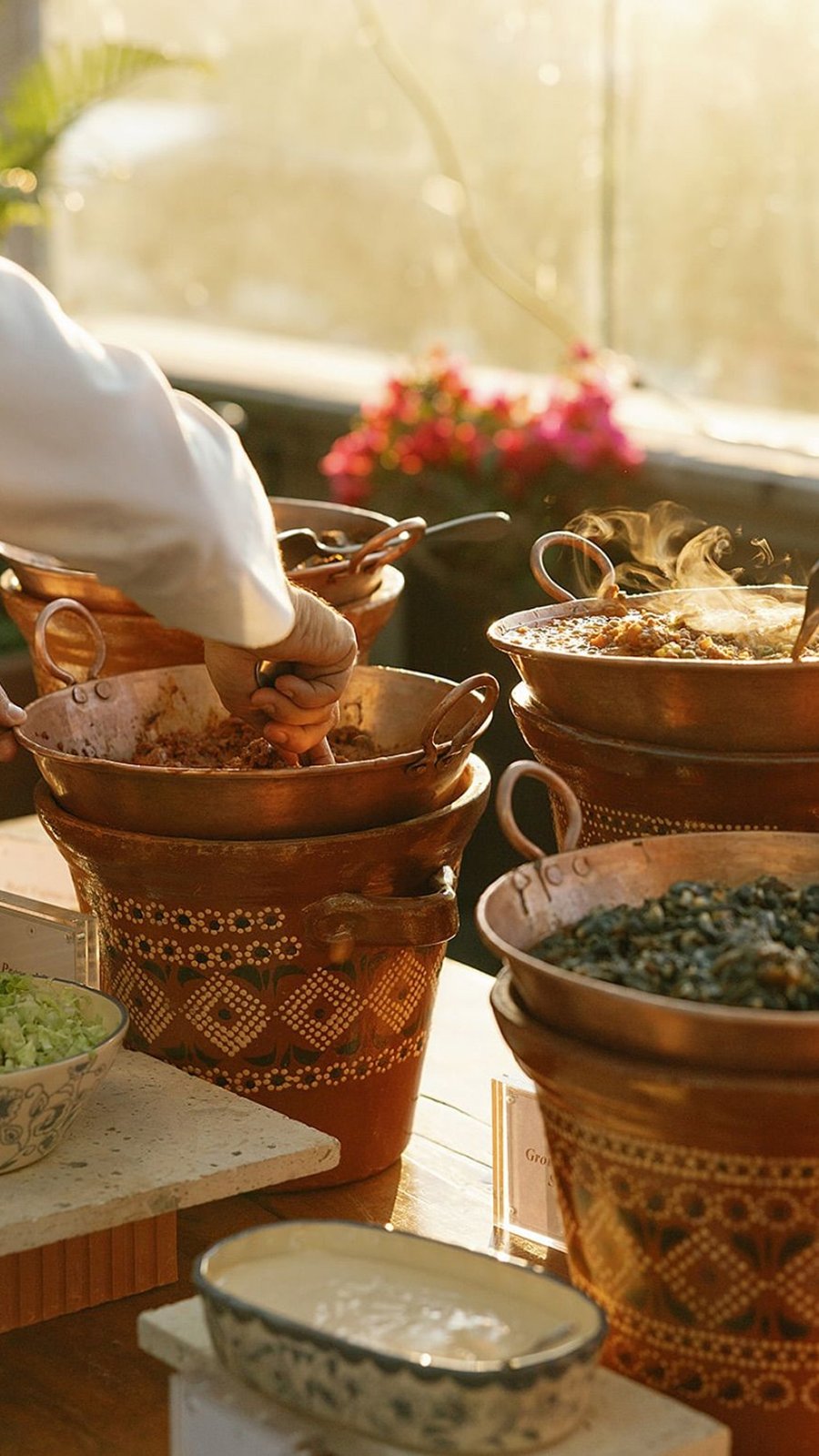 Cazuelas de cobre con guisados mexicanos servidos a los invitados