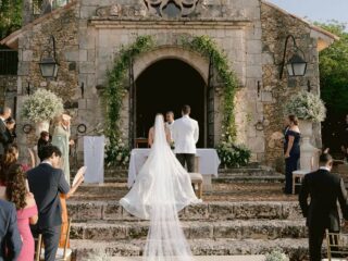 Novios frente al altar de una capilla de piedra durante su ceremonia