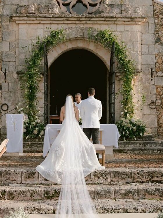 Novios frente al altar de una capilla de piedra durante su ceremonia