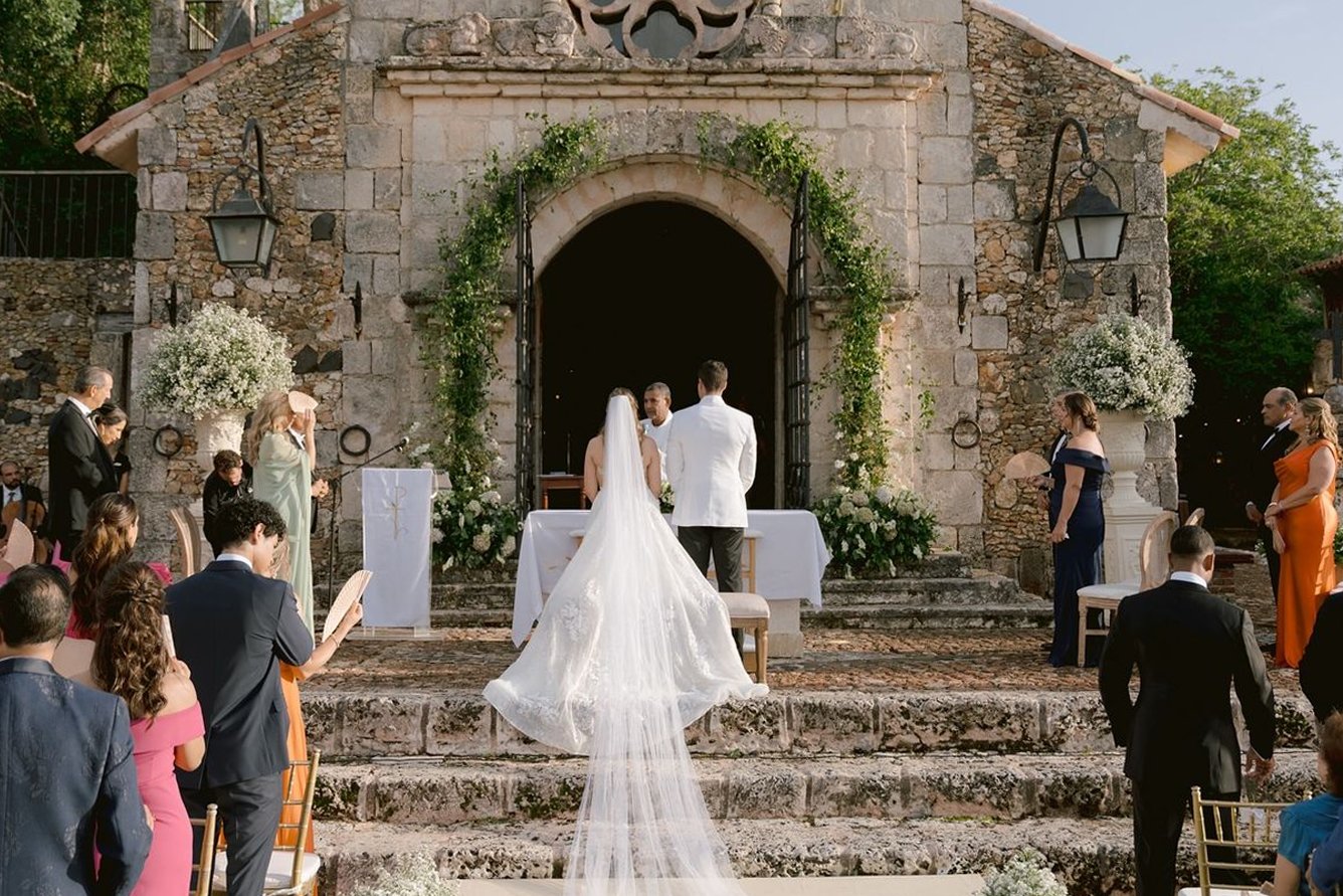 Novios frente al altar de una capilla de piedra durante su ceremonia